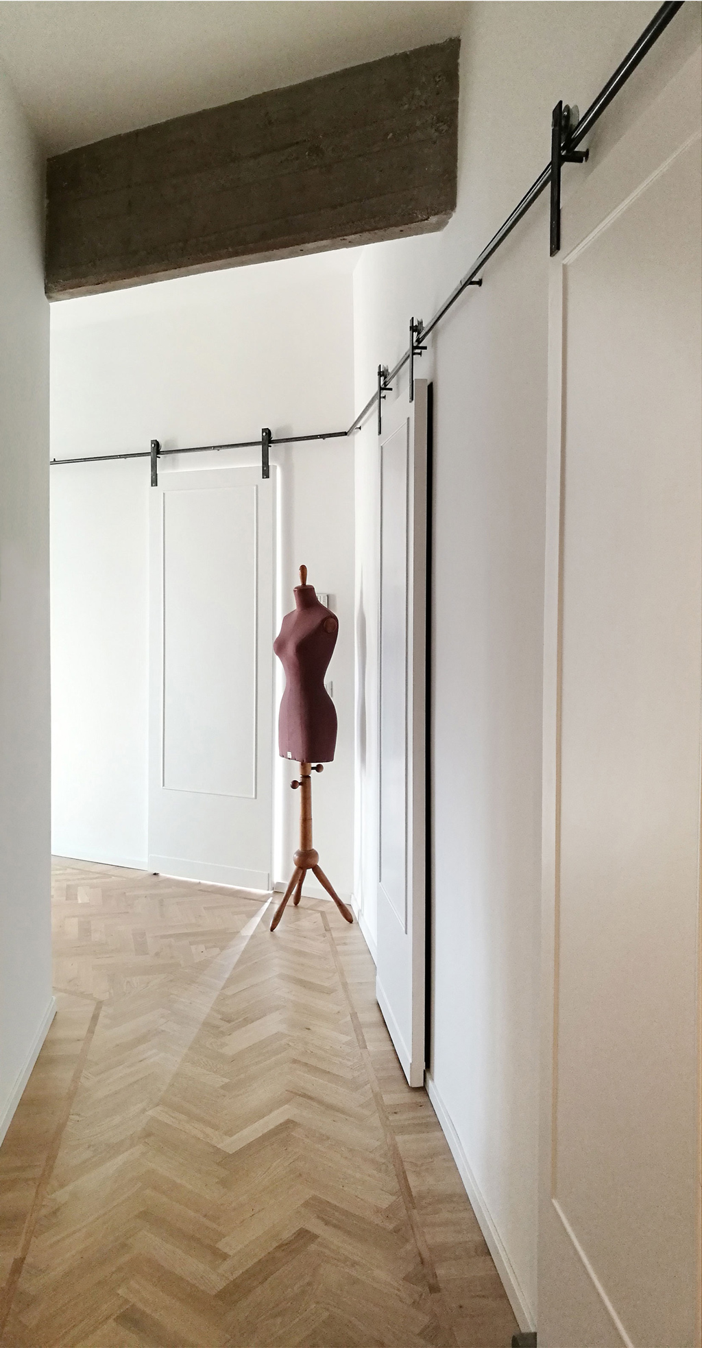 corridor entrance with white sliding panel doors and clothes dummy